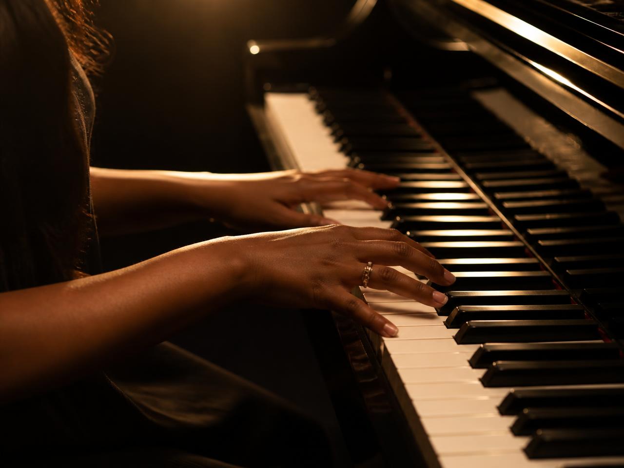 Close-up of a student's hands playing worship chords on a keyboard